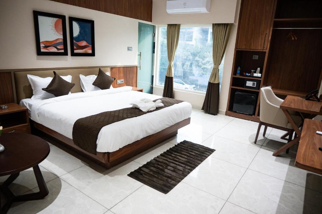 古瓦哈提Hotel SUI的一间卧室配有一张大床、一张桌子和一张书桌