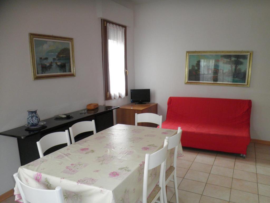 利多迪耶索罗Villa Nicole 2 camere的客厅配有桌子和红色沙发