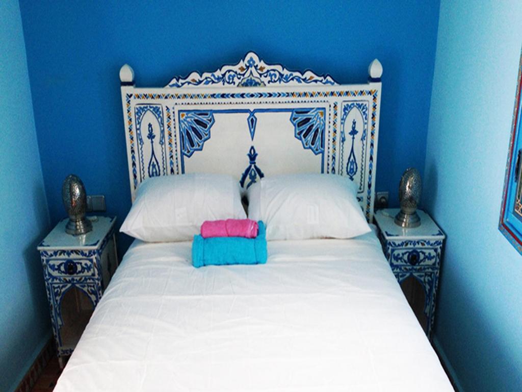 舍夫沙万达尔阿尔迪酒店的一间蓝色卧室,配有白色床和2个床头柜