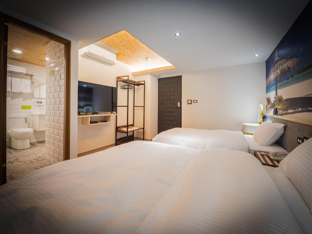 高雄良辰吉时精品旅店 的酒店客房带两张床和一间浴室