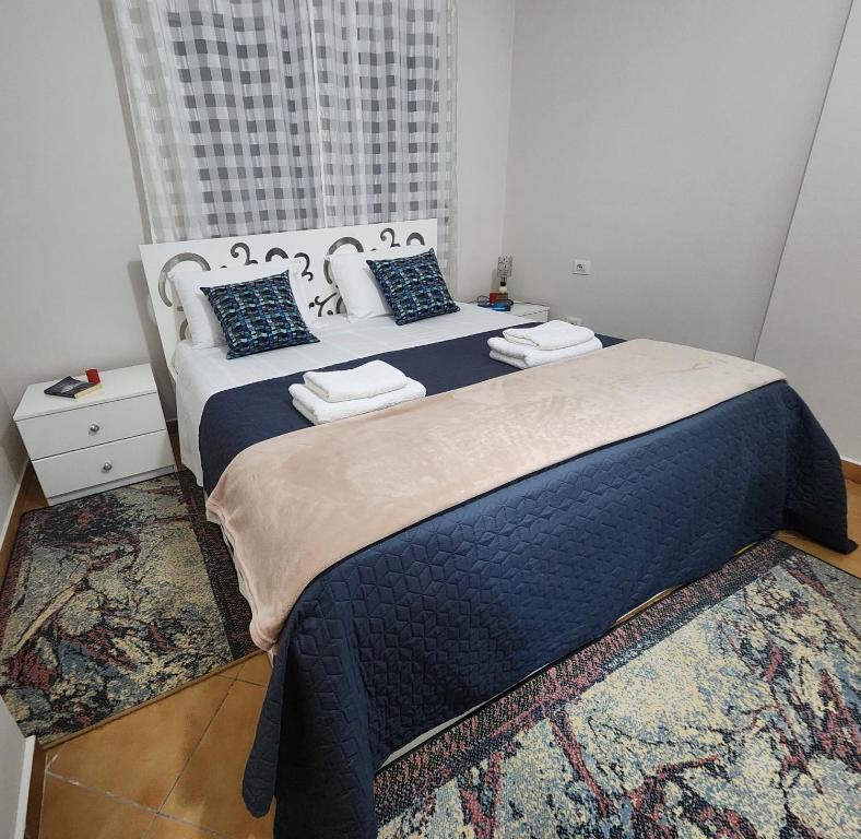 地拉那cancel的一间卧室配有一张大床,提供蓝色的床单和枕头