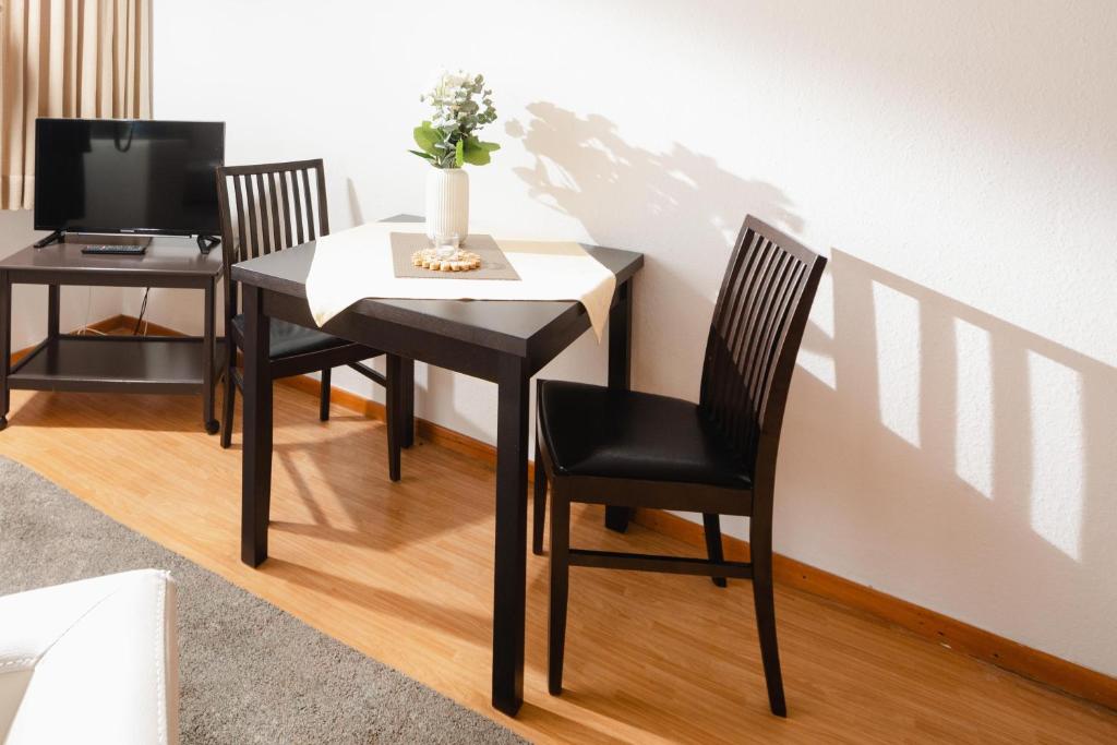 诺德奈Haus Meeresblick Wohnung 2的餐桌、两把椅子和电视