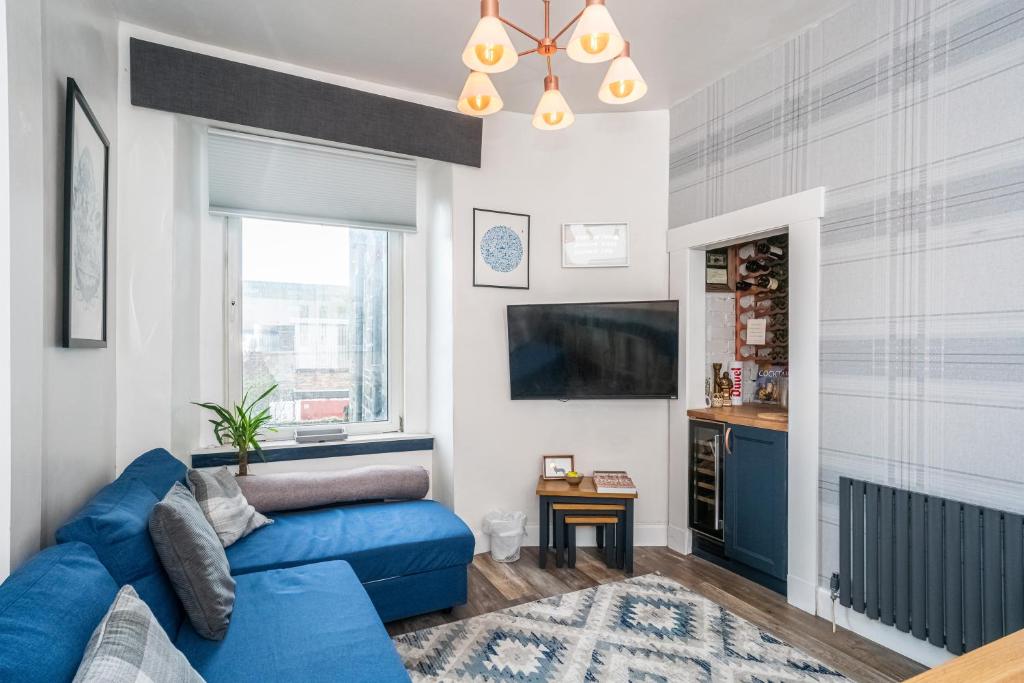 爱丁堡Pass the Keys Trendy Historic flat sleeps 4 to 6 near Leith Shore的客厅配有蓝色的沙发和电视