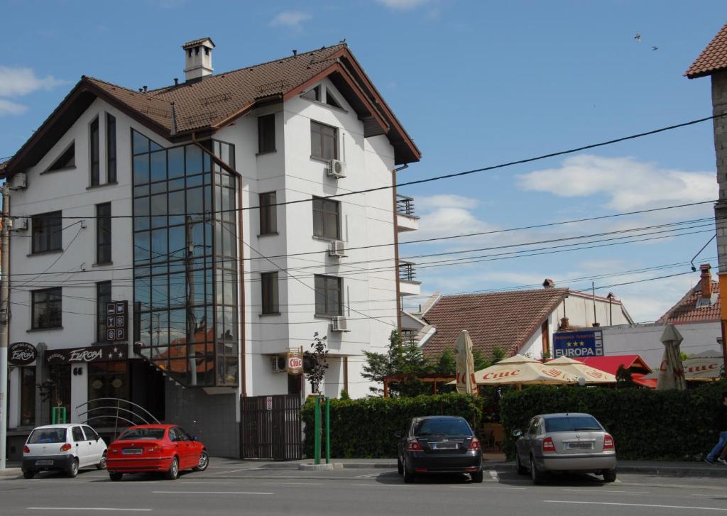 德罗贝塔-塞维林堡图尔努尼卡欧罗巴旅馆的一座白色的房子,前面有汽车停放