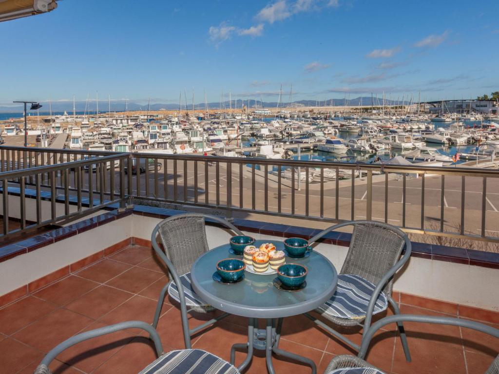 莱斯卡拉Apartment Port L'escala-1 by Interhome的一个带海港的阳台的桌椅