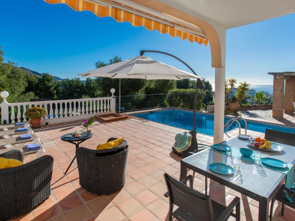 弗里希利亚纳Holiday Home Villa Alegria by Interhome的一个带桌子和遮阳伞的庭院和一个游泳池