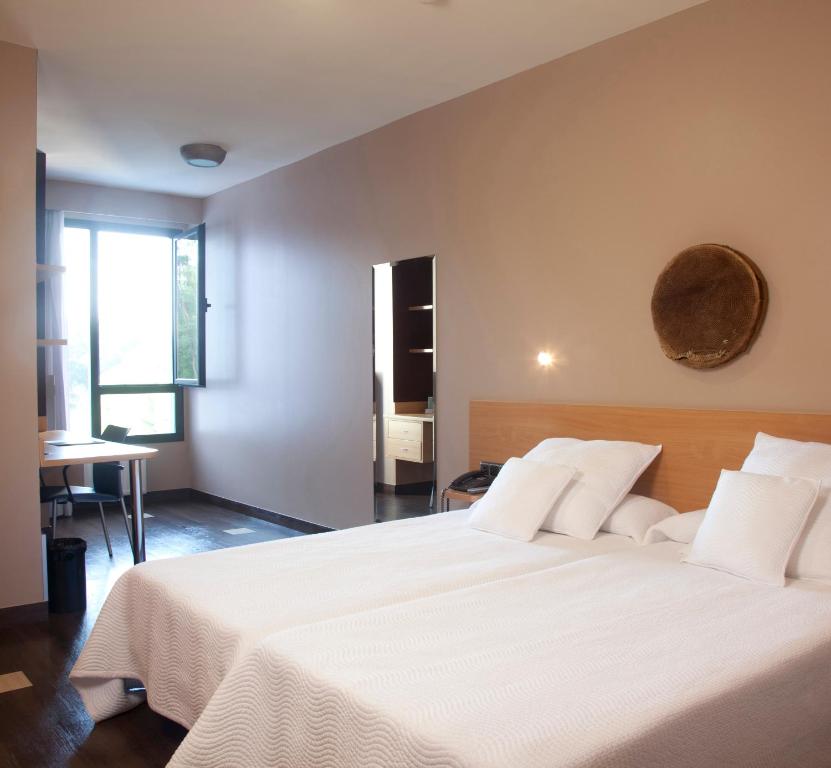 圣塞瓦斯蒂安欧拉莱茵酒店的一间卧室配有一张带白色床单的大床