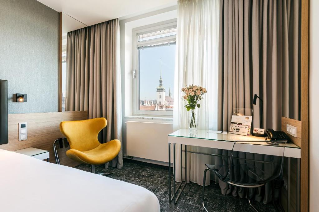 布尔诺Hotel International Brno的配有一张床、一张书桌和一扇窗户的酒店客房