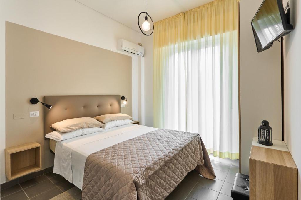 里米尼Hotel Villa Perazzini的一间卧室配有一张大床和电视