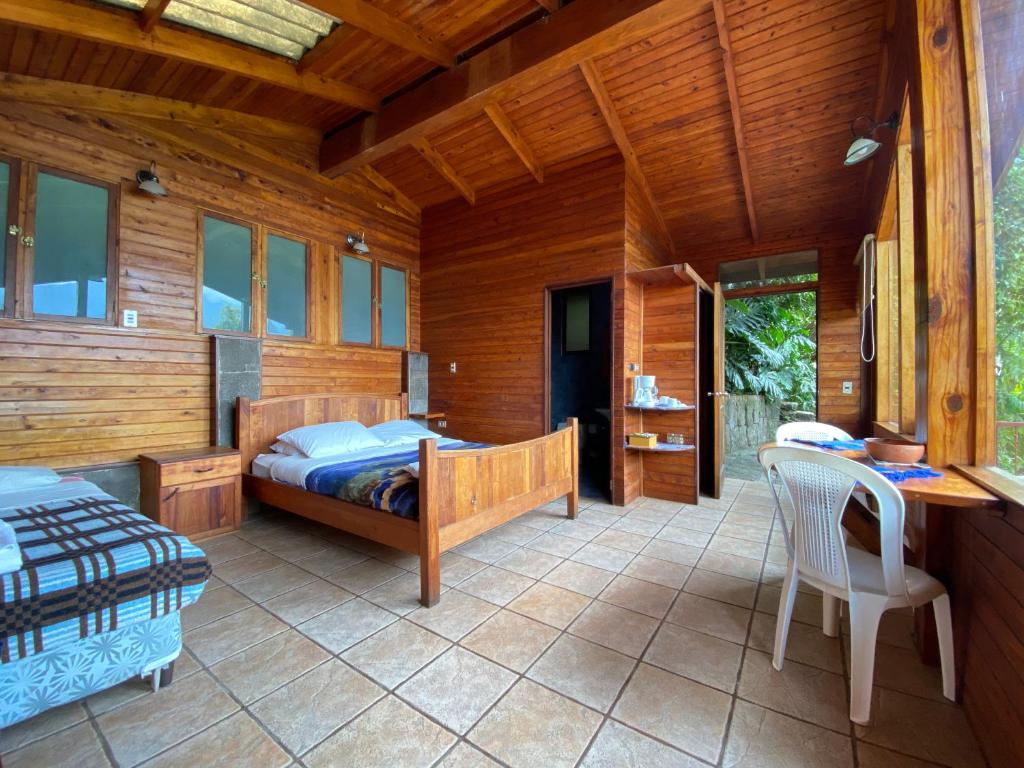 圣胡安拉拉古纳Lakefront Chalet的卧室配有一张床和一张桌子及椅子