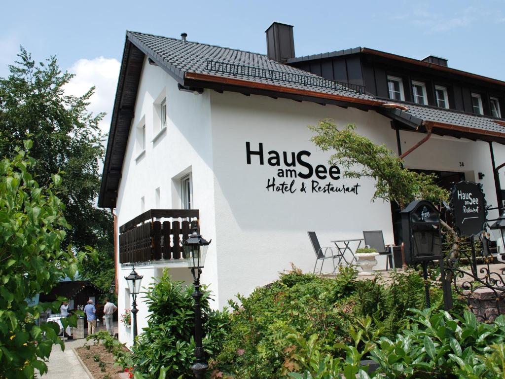 辛茨海姆Das Haus am See的白色的建筑,带有读物的标志,眼睛被阻塞