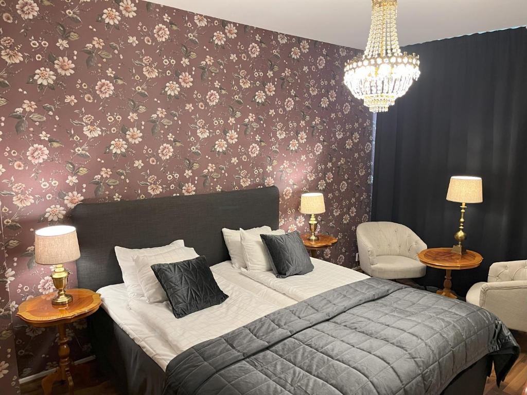 特罗尔海坦贝尔酒店的一间卧室配有一张带花卉墙壁的床