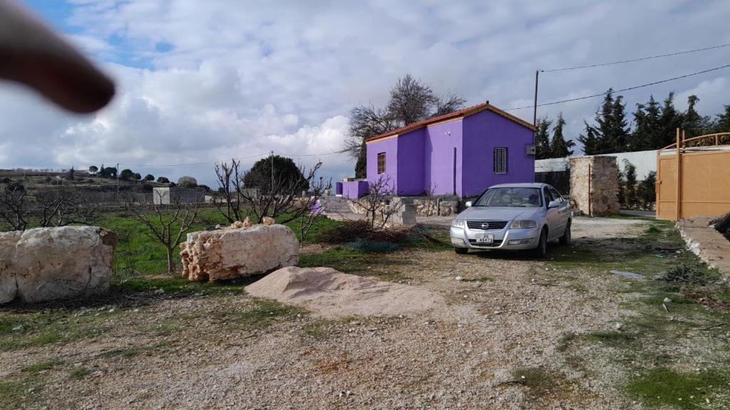 杰拉什Jerash mountain studio chalet شاليه جبال جرش و عجلون的一辆停在紫色房子前面的汽车