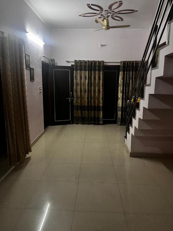 巴雷利Shiv mahima nivas的走廊设有楼梯和吊扇