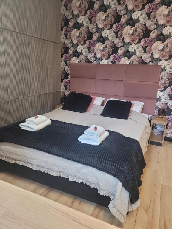 埃尔布隆格Apartament w sercu Elbląga的一间卧室配有一张大床和两条毛巾