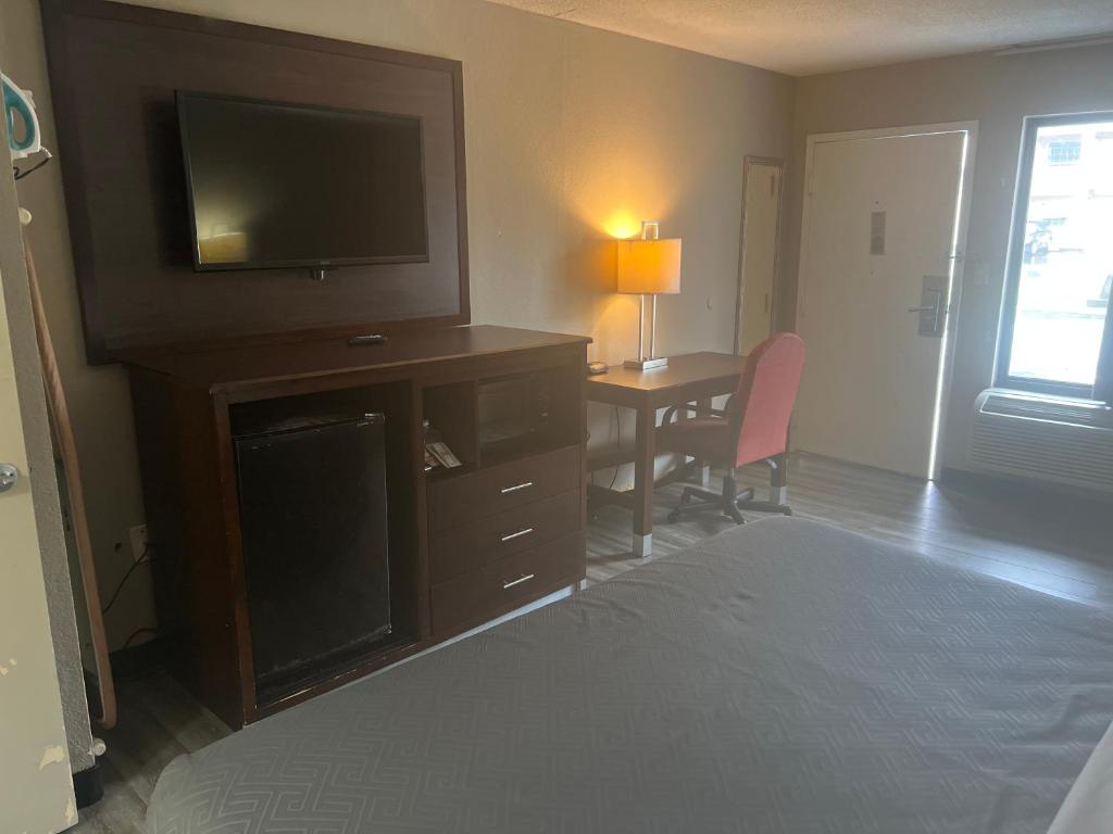 佛罗伦萨佛罗伦斯伊克诺旅店的一间卧室配有一张床和一张书桌及电视