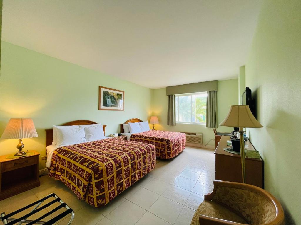 科罗萨尔Princess Vegas Hotel & Casino的酒店客房,配有两张床和椅子