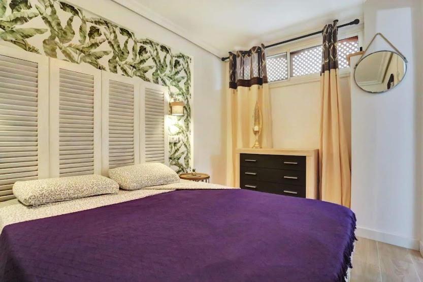 滨海帕尔姆Margherita House Tenerife, Wonderful Ocean View的一间卧室设有紫色的床和窗户