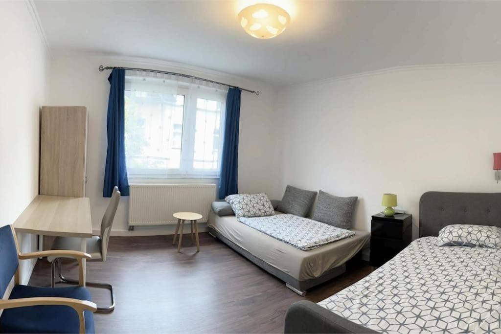 杜伊斯堡2-Schlafzimmer-Wohnung mit Parkplatz-Balkon-Küche- Garten, Nahe DUS Airport, Messe的一间卧室配有一张床、一张沙发和一张桌子