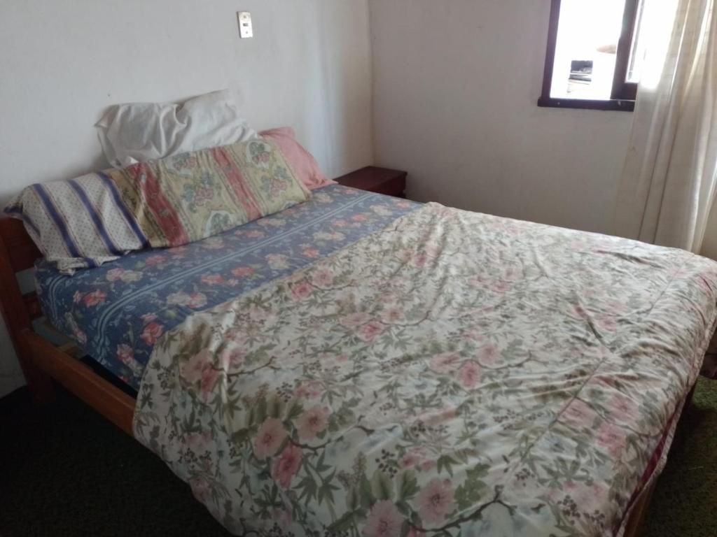 马德普拉塔Casa, quincho, garage y parque.apta 10 personas的一间卧室配有一张带花卉棉被的床