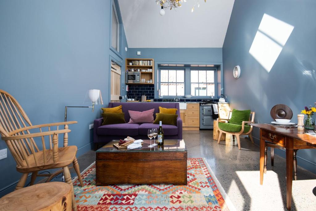 East LintonShepherd's Bothy at Papple Steading的客厅配有紫色沙发和椅子