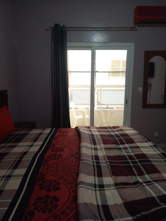 达喀尔Peace N Quiet aux Almadies的一间卧室设有一张床和一个阳台的窗户。
