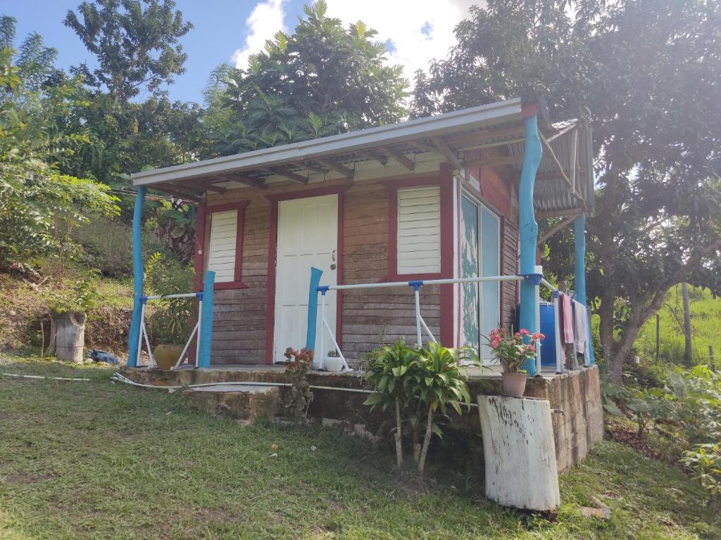 HigueyLa Loma Camping的一个小房子,设有门廊和蓝色的柱子