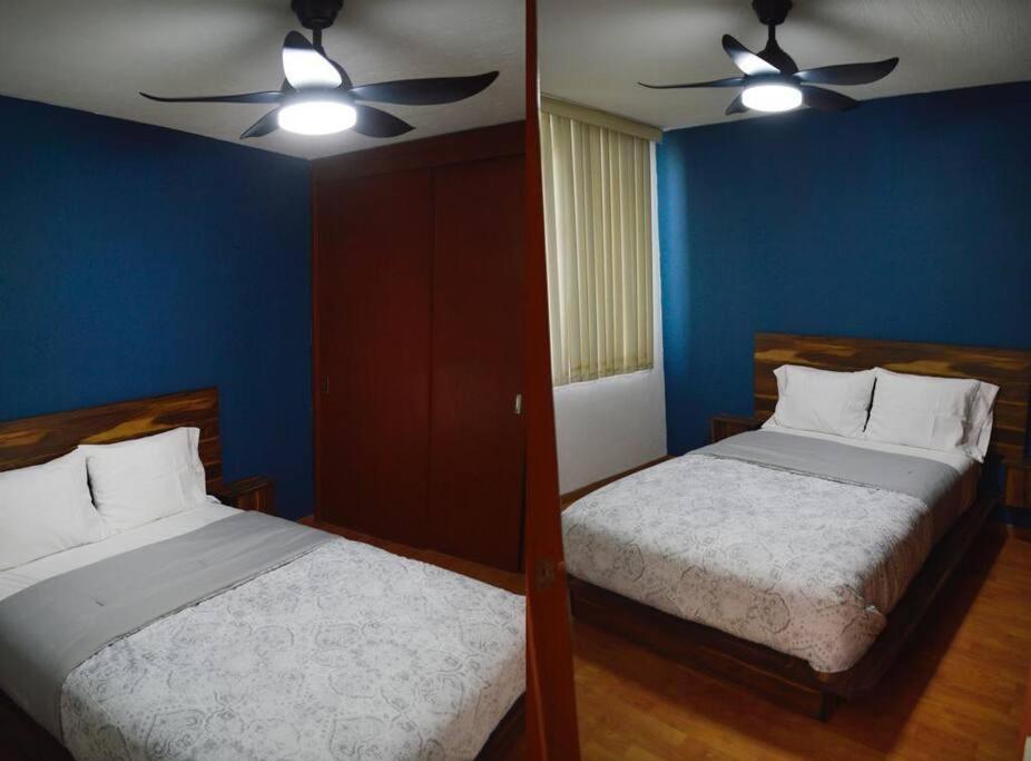 瓜达拉哈拉Preciosa y Cómoda Casa en Coto Tlaquepaque Centro.的一间卧室配有两张床和吊扇