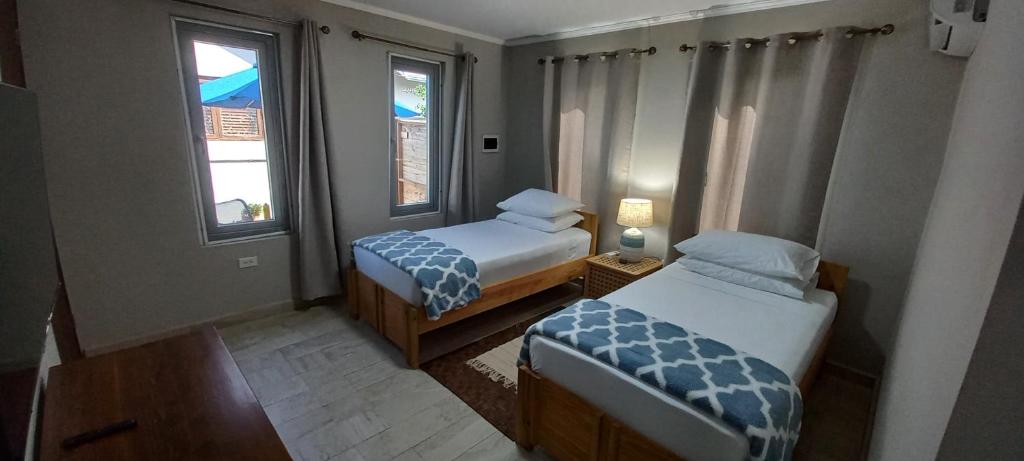 棕榈滩SEMEREL APARTMENT的小房间设有两张床和两个窗户