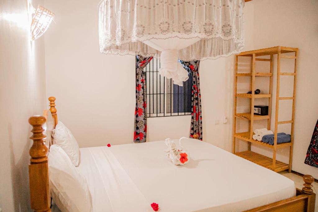 江比阿Villa Kikadini的一间卧室配有一张带吊灯和窗户的床。