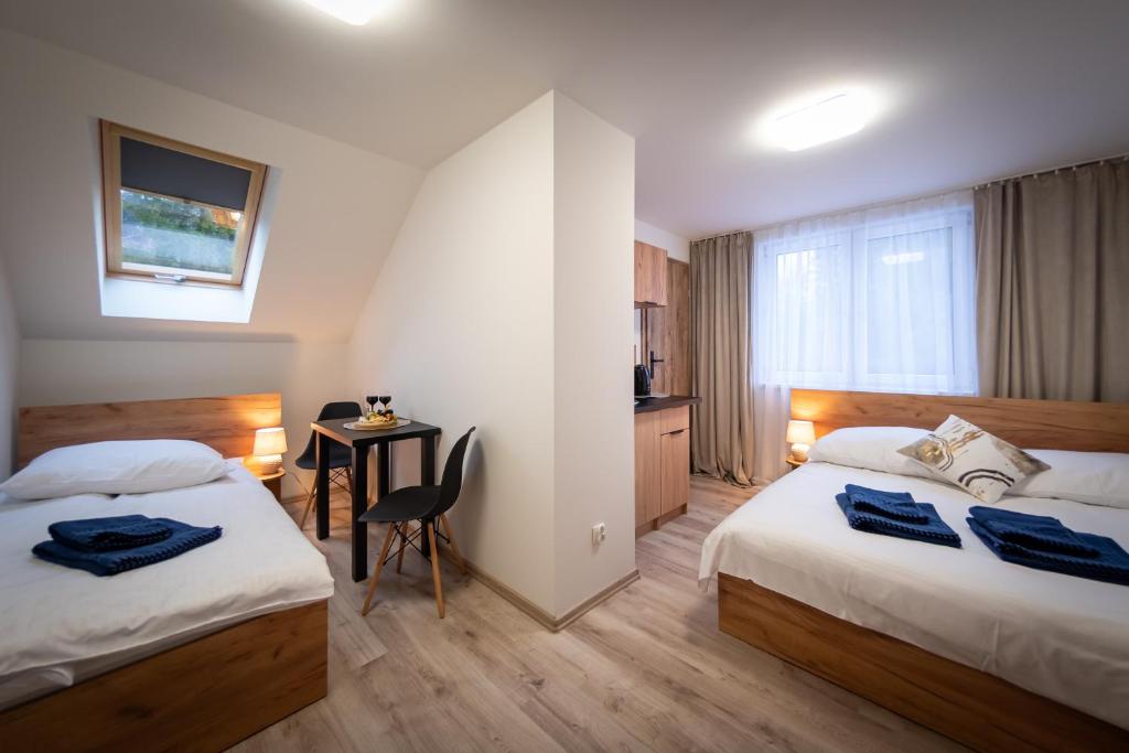维斯瓦Pokoje Vik-House的酒店客房设有两张床和一张桌子。