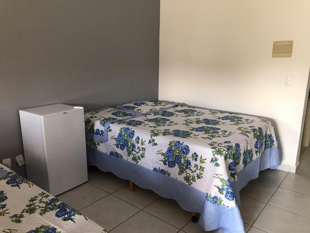 阿瓜斯迪林多亚Pousada Vida feliz的一间带两张床和冰箱的小卧室