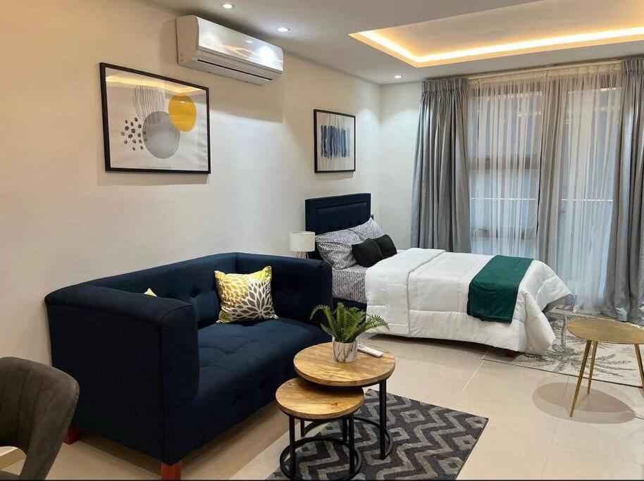 阿克拉Luxury & Modern Studio Apartment的客厅配有蓝色的沙发和床。