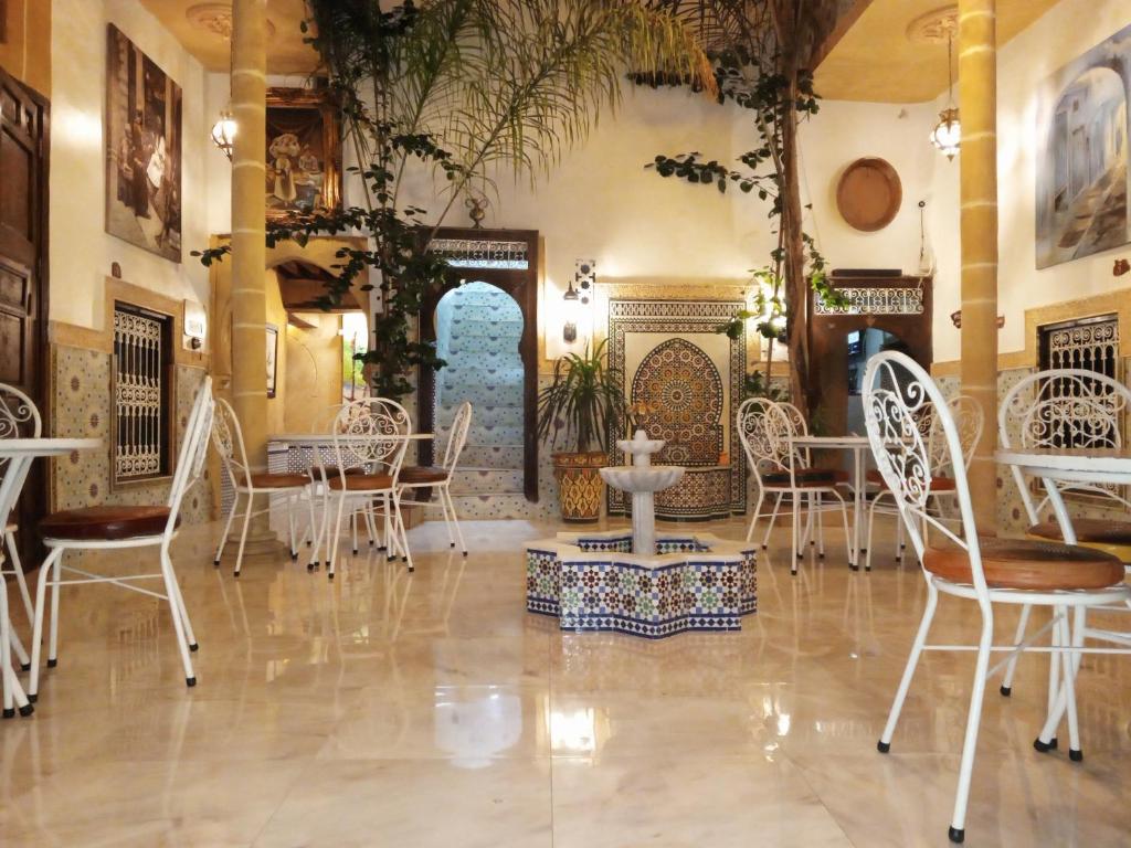 拉巴特RIAD Dar Ouezzani的一间配备有白色椅子和桌子的用餐室