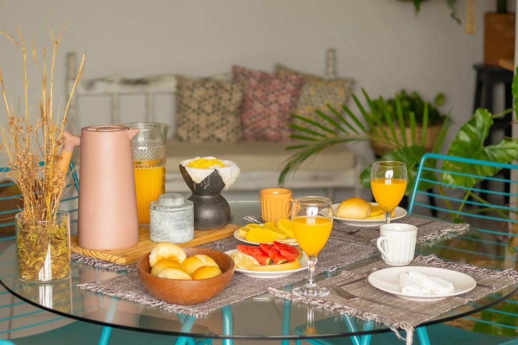 大坎皮纳Refúgio Urbano的玻璃桌,带食物和橙子,还有橙汁