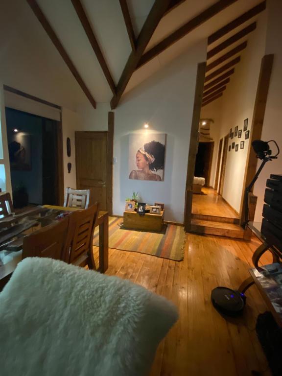 巴拉斯港Habitación en Casa Cumbres del Lago的客厅铺有木地板,墙上挂有绘画作品