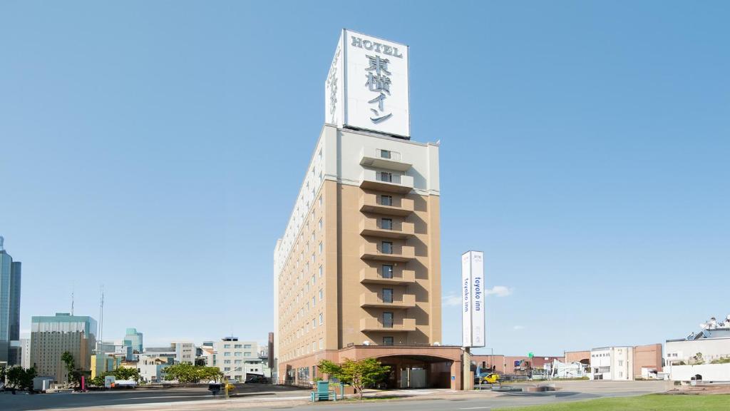 旭川Toyoko Inn Hokkaido Asahikawa Ekimae Ichijo dori的一座高大的建筑,上面有标志