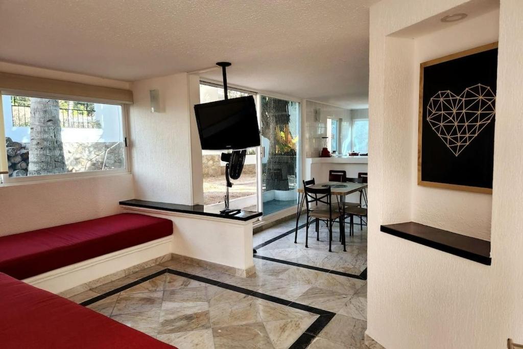 阿卡普尔科Secretos del Sol Acapulco villas a 5 minutosdel mar的客厅配有红色沙发和电视
