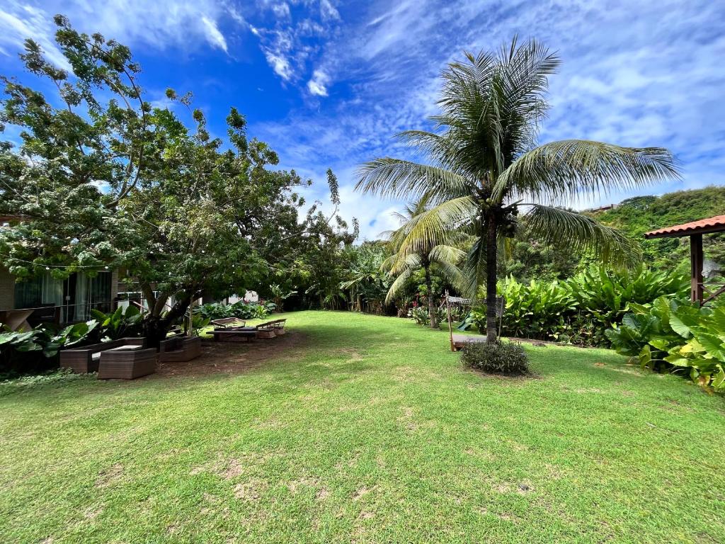 费尔南多 - 迪诺罗尼亚西姆帕提娅小岛旅馆的庭院里种有棕榈树的草坪