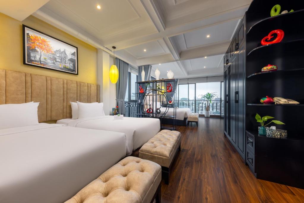 河内Golden Legend Boutique Hotel的酒店客房,设有两张床和一张沙发