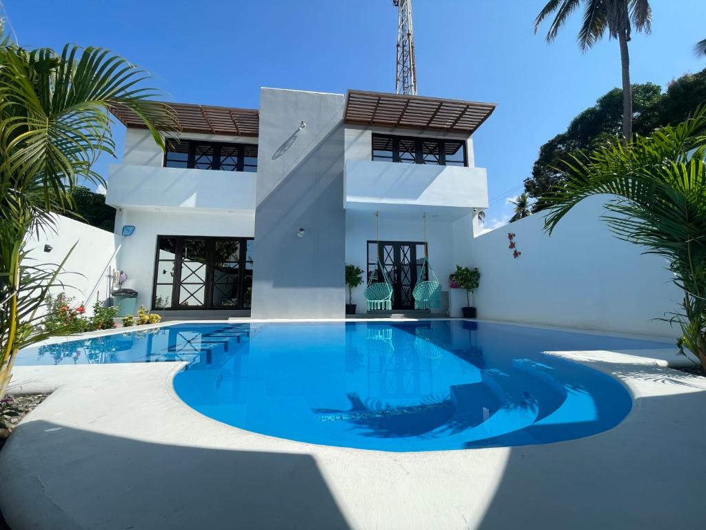 El DesengañoCasa AbrahamMya Playa Linda 3 bed home with pool.的棕榈树屋前的游泳池