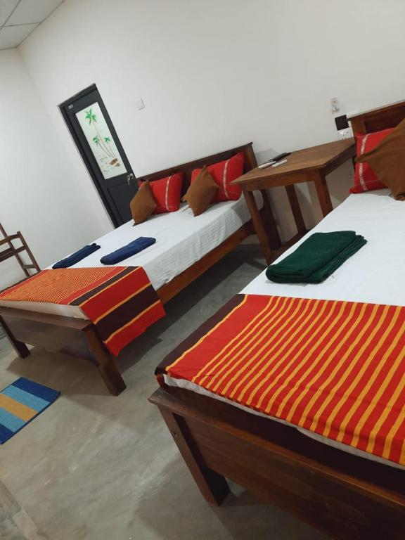 阿努拉德普勒JD Resort的两张睡床彼此相邻,位于一个房间里