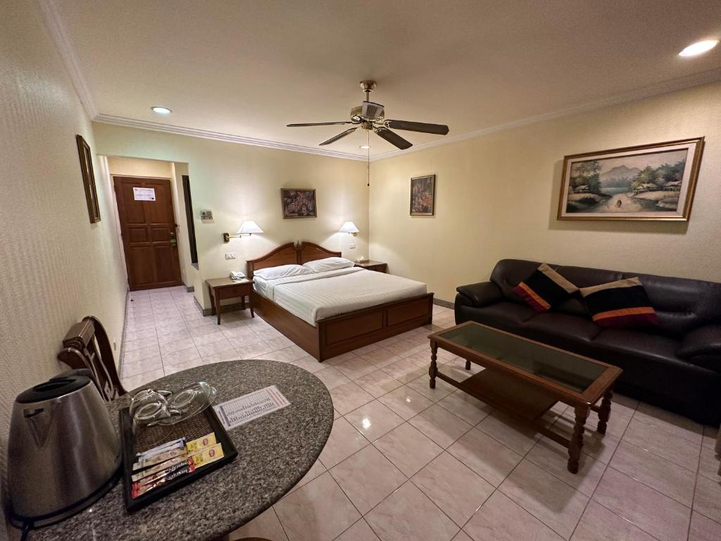 芭堤雅市中心Copa Hotel的客厅配有床和沙发