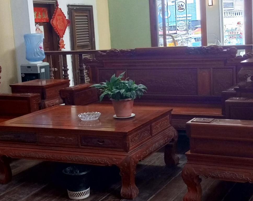 芒赛Dansavanh Hotel的客厅配有木桌,上面有盆栽植物