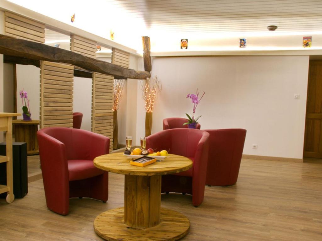 BourgnacÔ Délices de la Monnerie的客厅配有椅子、桌子和桌子