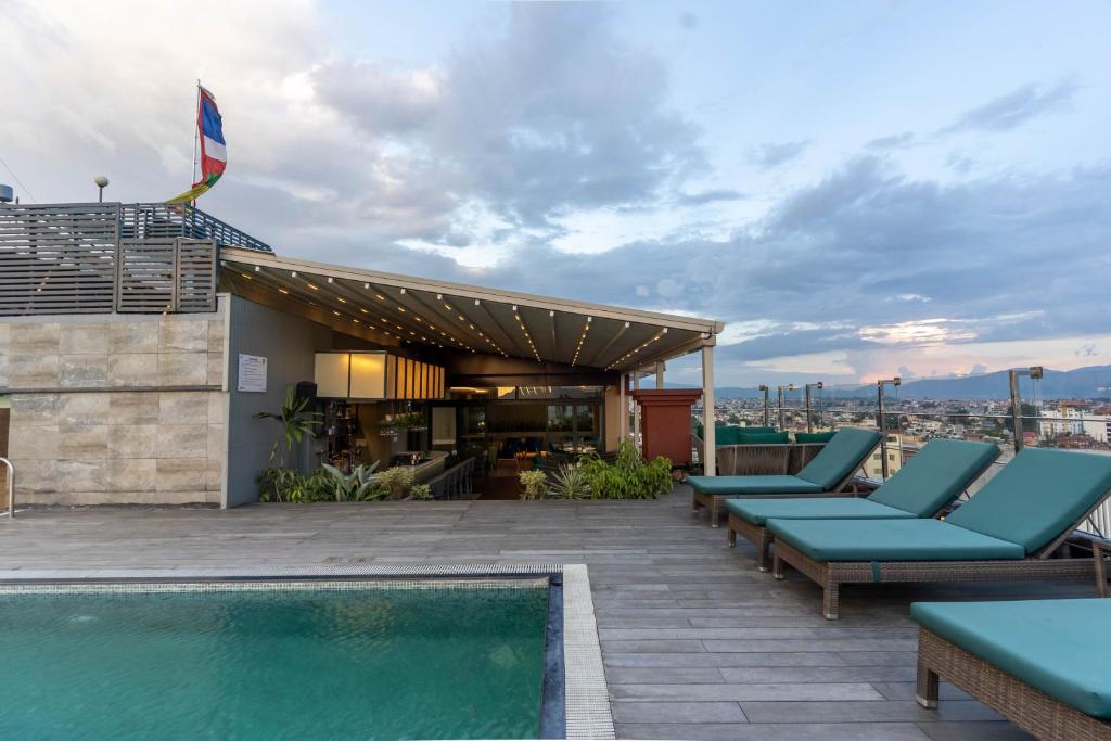 加德满都香巴拉酒店 的一个带躺椅的屋顶露台和游泳池