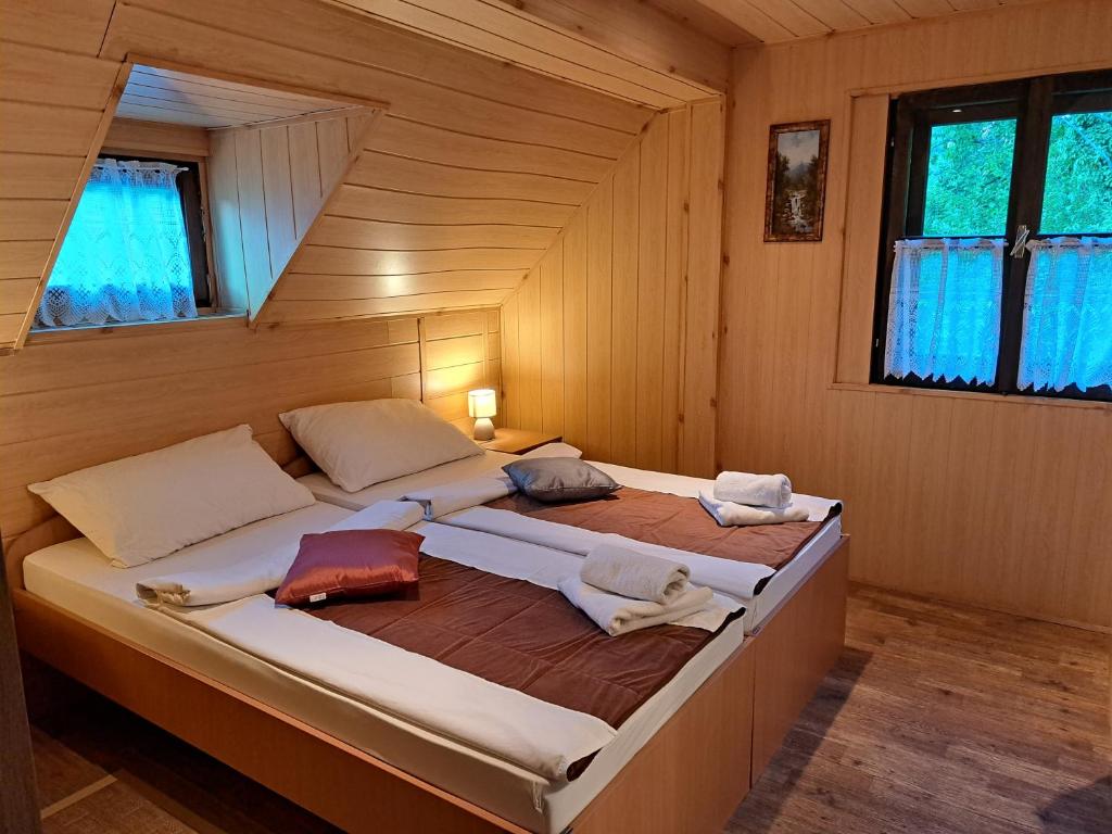 普利特维采湖San Korana的木制客房内的一间卧室配有两张床