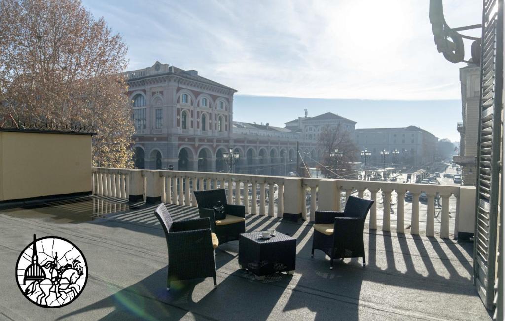 都灵博洛尼亚酒店的一个带桌椅的阳台和一座建筑