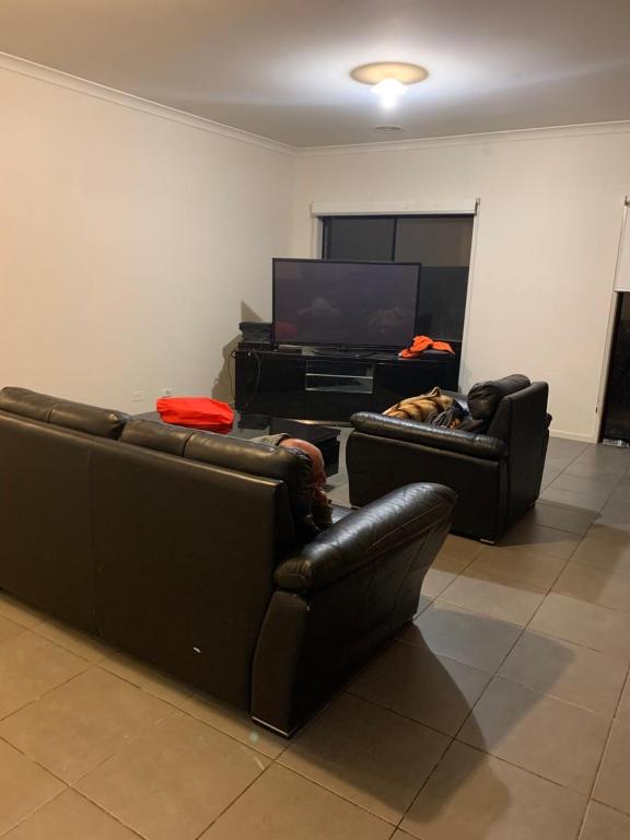吉隆坡Cozy Sanctuary的客厅配有两张真皮沙发和一台平面电视