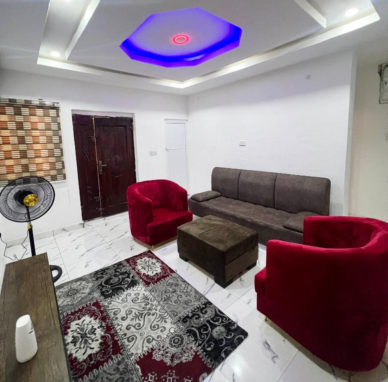卡拉巴尔Signature Residence的带沙发和红色椅子的客厅